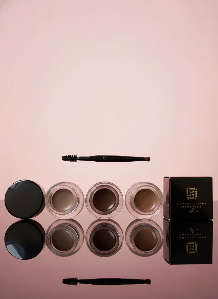 Eyebrow product set with multiple shades and a box on a pink background