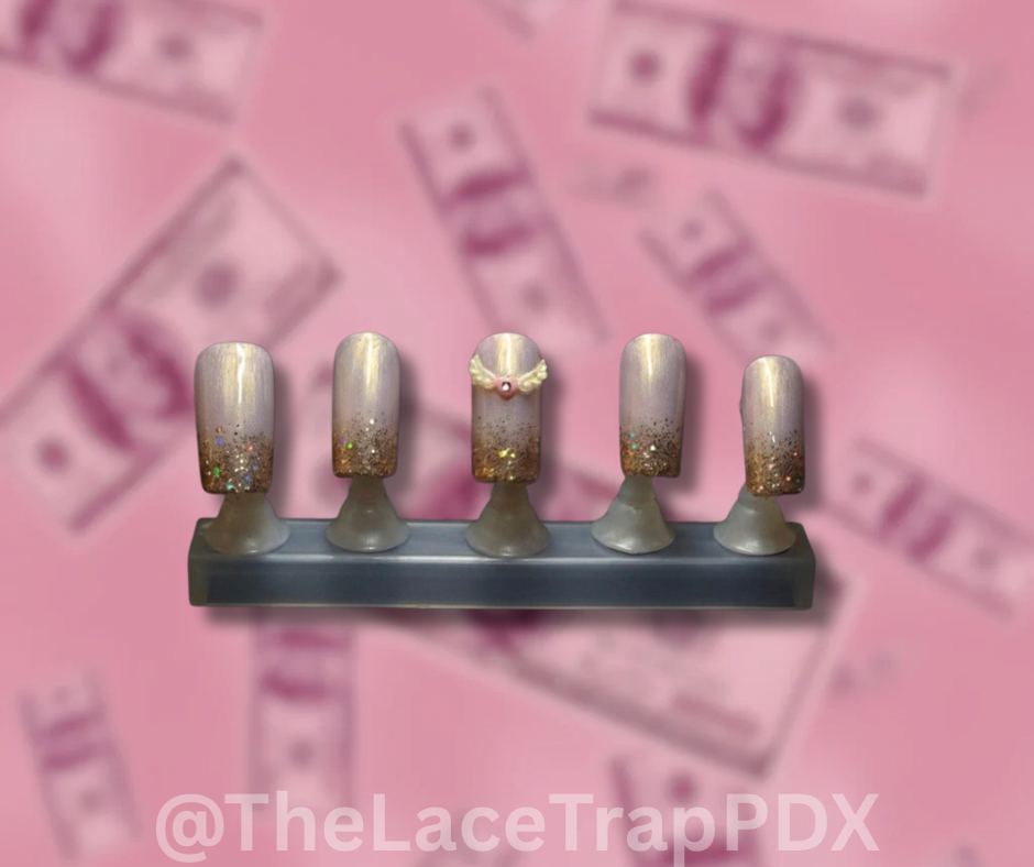 Set of false nails with glittery tips on a pink background with 'The Lace Trap PDX' branding.